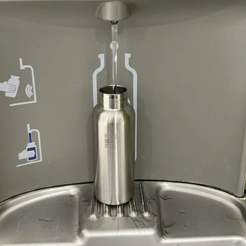 Sitainless steel insulalted water bottle being filled at an EZ H2O water station.