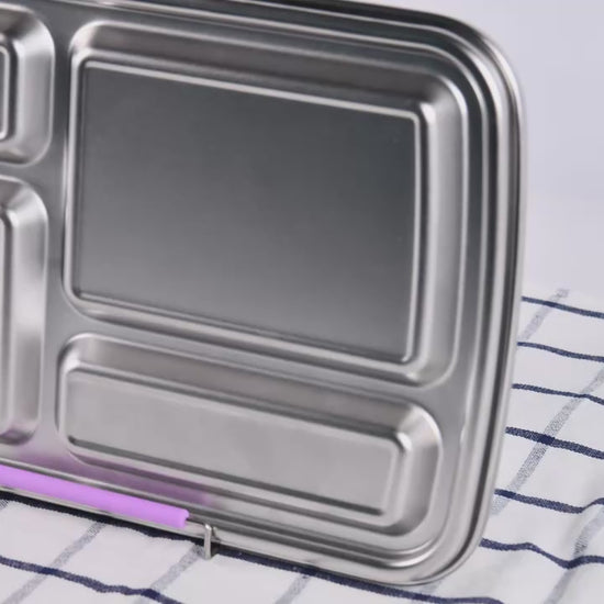 4-compartment stainless steel bento box with purple lid being opened and shown.