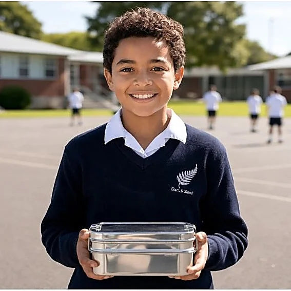 Child holding stainless steel lunchbox at New Zealand school